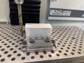 A drill next to some stock to be machined
